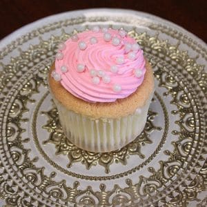 A CC-009 Gold cupcake with chocolate mousse filling sits on an ornate silver-patterned plate.