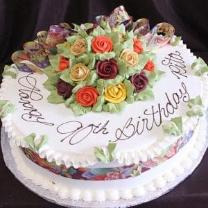 The THX-021 is a round birthday cake featuring realistic, colorful buttercream roses and leaves. "Happy 90th Birthday" is written in script on white icing, with a floral-patterned ribbon encircling the sides.