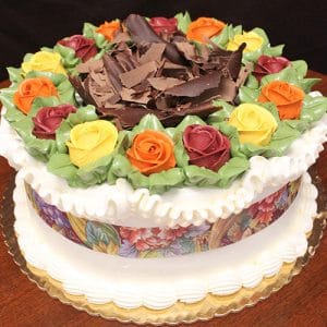 The THX-022 is a round cake adorned with yellow, red, and orange buttercream roses, green leaves, white icing borders, chocolate shavings in the center, and presented on a golden cake board.