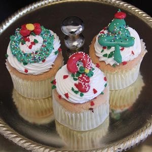 A CH-065 Display Christmas Decor Gold cupcake with chocolate mousse filling is topped with gold icing and holiday-themed decorations for a festive touch.