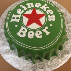 The BD-025 Heineken is a round cake designed as a green beer bottle cap with white "Heineken Beer" text and a large red star in the center, presented on a silver floral-patterned tray.