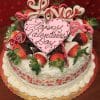 The VC-005 Display Pina Colada cake features chocolate-dipped strawberries, whipped cream, pink and white chocolate hearts, a "Happy Valentines Day" heart sign, a “Love” topper, and heart designs on the sides for Valentine’s decor.
