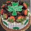 The STP-004 cake features chocolate and cream frosting, chocolate-dipped strawberries, chocolate shavings, green shamrocks, and a large green shamrock topper with “Happy St. Patrick’s Day.”.