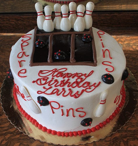 The ST-008 Bowling Red/Brown is a round birthday cake decorated with red icing words "Happy Birthday Larry, Pins, Spare" and features a chocolate bowling lane with fondant pins and balls.