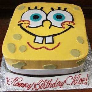 A CB-009K square cake decorated as SpongeBob SquarePants with yellow icing, big blue eyes, and a wide smile. A front plaque reads "Happy Birthday Chloe!" in red script.