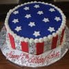 The JC-012 is a round cake with red and white vertical stripes, silver anchors, a blue top with white stars, and a front plaque that says "Happy 75th Birthday John.
