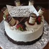 The BD-024H Hennessy birthday cake is round with white frosting, chocolate shavings, chocolate-dipped strawberries, mini Hennessy bottles on top, and a "Happy Birthday Julius" card in cursive, presented on a silver board.