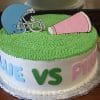 The BB-051 cake is round with green icing, topped with a blue football helmet and a pink megaphone. "BLUE VS PINK" is written in colorful letters on the side.