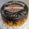 GR-001 is a round cake featuring a Harley-Davidson Motor Cycles logo on top, orange and yellow flames around the sides, and white icing with "Happy 50th Birthday Ted," served on a floral-patterned platter.
