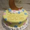 BB-055 is a round cake with yellow icing, pink and blue star decorations, white edging, and a large crescent moon on top. The message reads: Twinkle Twinkle Little Star, How we wonder what you are.