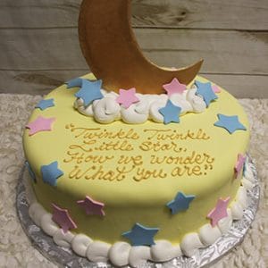 BB-055 is a round cake with yellow icing, pink and blue star decorations, white edging, and a large crescent moon on top. The message reads: Twinkle Twinkle Little Star, How we wonder what you are.