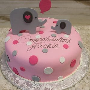 BB-042 is a pink cake decorated with gray, pink, and white polka dots, featuring two elephant toppers and a balloon. "Congratulations Jackie" is written in cursive on the cake.