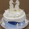 The BR-046 is a round cake topped with two large seahorses and white chocolate sea shells, featuring blue fondant waves along the bottom and additional white sea-themed decorations around the sides.