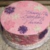The CH-037 is a round pink birthday cake with white, pink, and purple floral designs and "Happy 17th Birthday Varnai" written in purple icing, presented on a silver board.