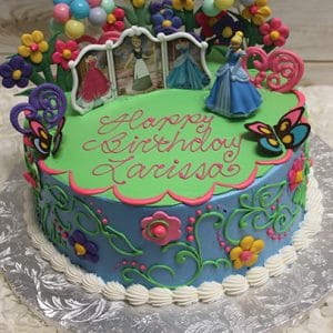 The SC-017 Cinderella is a colorful round birthday cake topped with Cinderella figurines, balloons, flowers, a butterfly, and "Happy Birthday Larissa" written in pink icing.