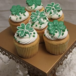 Six STP-007 gold cupcakes with Chocolate Bailey's mousse sit on a gold stand adorned with hanging crystal beads.