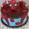 The SC-055 Spiderman cake is round with blue sides, red chocolate spider webs and spiders, topped with a 3D Spider-Man mask and web. "Happy Birthday Timony" is written in red icing on top.