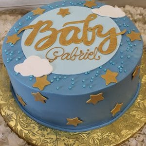 The BB-056 is a round blue cake with gold stars, white clouds, and blue sprinkles. "Baby Gabriel" appears in gold script on top, and the cake sits on a gold-patterned board.