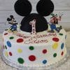 The CB-002E is a round birthday cake with colorful polka dots, Mickey Mouse and Goofy figures, a black Mickey ears topper, polka-dot number one, and "Happy Birthday Edson" in red icing.