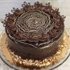 The BD-016 Boston Cream cake is a round chocolate cake with a glossy glaze, topped with a white and dark chocolate spiderweb, swirls of chocolate cream, chocolate decorations, and sliced almonds around the base.