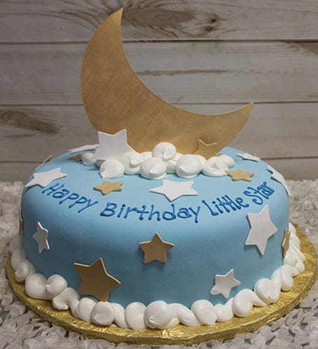 The CB-034 is a round blue birthday cake with white and gold stars, white frosting swirls, a large gold crescent moon topper, and "Happy Birthday Little Star" written in blue icing.