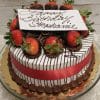 The BD-001 cake features chocolate-dipped strawberries, chocolate drizzle, a red ribbon, and a white "Happy Birthday Stephanie" plaque in cursive. Choose your preferred flavor. Presented on a gold tray.