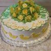 BB-009 is a round white cake topped with yellow duck shapes, green and yellow icing roses, yellow icing butterflies, and "Welcome Bebe" written in yellow icing.