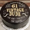 The GR-009 is a round chocolate cake with white lettering: “Premium Quality Aged 61 Years, Vintage Dude, The Man, The Myth, The Legend,” served on a silver decorative board.
