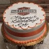 The GR-003 is a round cake featuring the Harley-Davidson logo, orange and white icing, an orange ribbon on the side, and “Happy Birthday Rob” in black icing. Presented on a gold tray.