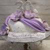 The BD-055A Lavender Swag is an elegant birthday cake adorned with large purple and white flowers, lavender fondant drapes, a “30” topper, and “Happy Birthday Desiree” written on the front, presented on a silver stand.