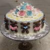 The BB-012 is a round cake featuring chocolate teddy bears, pink and blue bows, pink and blue icing roses, and the words "Girl or Boy?" written in yellow icing.