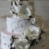 The WD-096 is a three-tiered white wedding cake with large white flowers, dark branches, and a heart with A + G carved on the side like a tree. It sits elegantly on a silver stand.