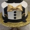 The GR-010 is a round cake styled as a tuxedo, featuring black suspenders, black buttons, a gold bow tie, and a black mustache on top, presented on a gold cake board.