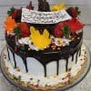 The THX-012 is a round cake with white frosting, chocolate ganache drips, whipped cream swirls, colorful leaf-shaped decorations, strawberries, and a white chocolate plaque reading “Happy Birthday Lisa.”.