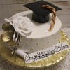 GC-045: White round cake with a large white rose, gold flower, gold pearl accents, and a black graduation cap with gold tassel. “Congratulations Dilma” sign on top.