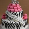 The TC-150 is a two-tier cake with black and white zebra stripes, pink fondant loops, and a large 16 on top. A white ribbon across the cake reads "Happy Sweet 16 Birthday.