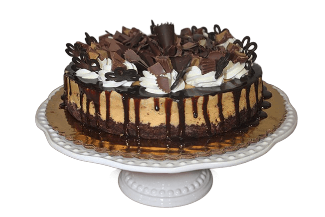 Chocolate cheesecake topped with chocolate shavings, whipped cream, and chocolate drizzle on a cake stand