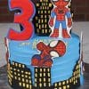 Spider-Man themed birthday cake with city skyline design and red number three topper