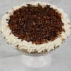 Turtle pie topped with chocolate drizzle, caramel, and chopped pecans with whipped cream border