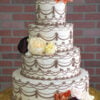 WD-111 is a four-tier white wedding cake decorated with intricate brown piping and clusters of burgundy, cream, and warm-toned flowers.